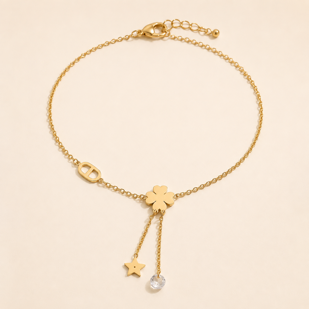 Celestial Clover gold anklet with star and clear crystal chain tassels on luxury ivory background