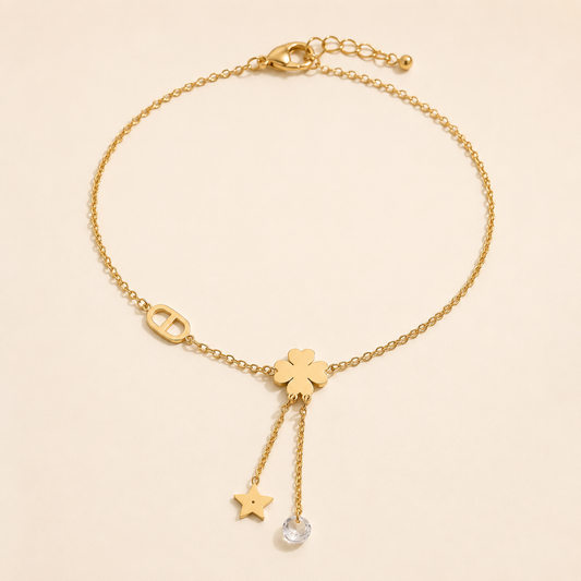 Celestial Clover gold anklet with star and clear crystal chain tassels on luxury ivory background