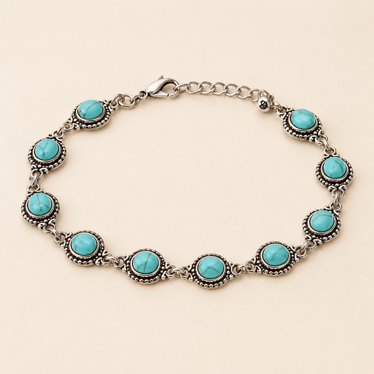 Ethnic Turquoise Boho anklet with veined turquoise cabochons in antique silver settings on luxury ivory background