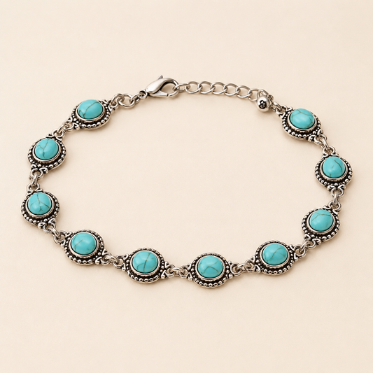 Ethnic Turquoise Boho anklet with veined turquoise cabochons in antique silver settings on luxury ivory background