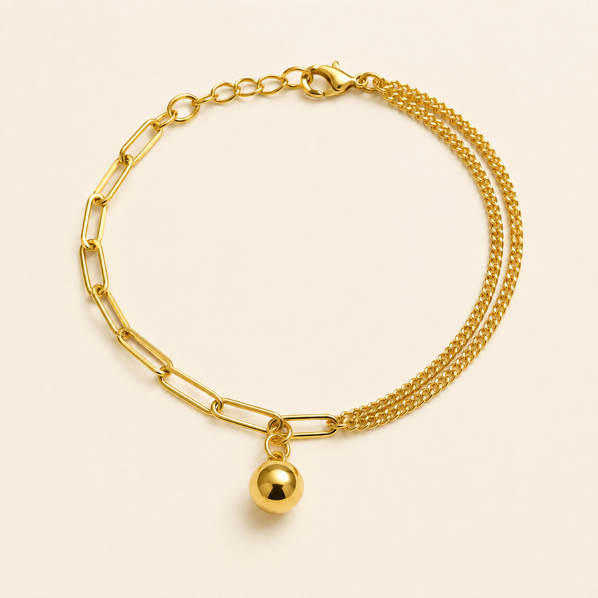 Asymmetric gold anklet with paperclip links, double curb chains and ball pendant on warm ivory