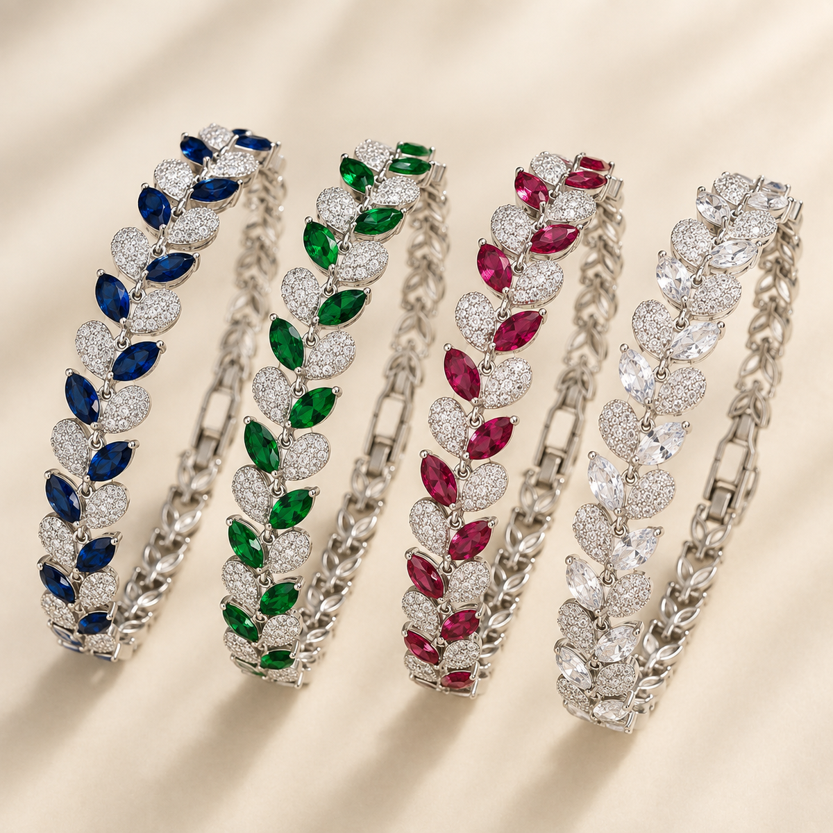 Leaf and Fishtail pavé zircon silver bracelets in blue, green, rose red and clear colour options on luxury ivory background