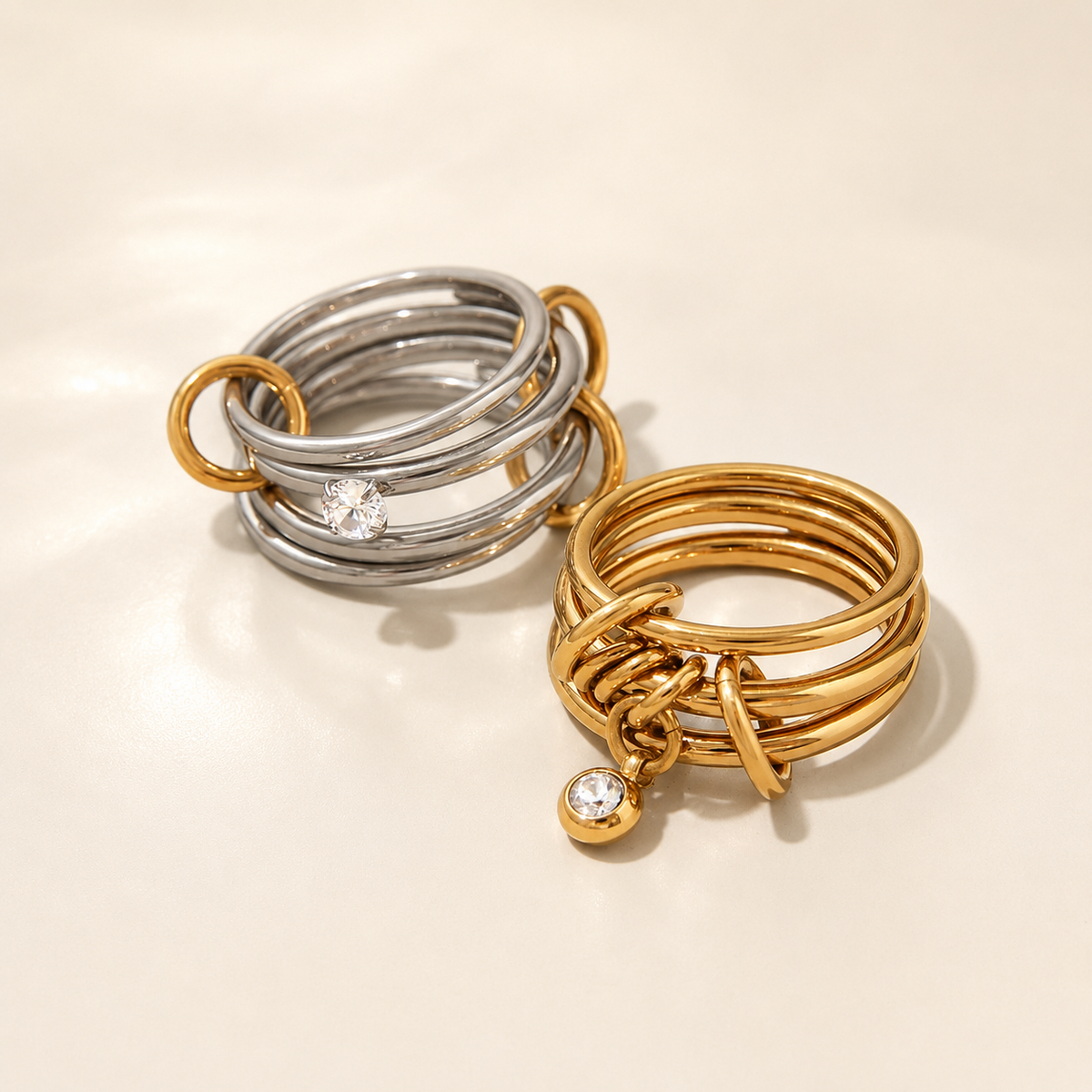 Multi-Layer Zirconia Stacking Rings in gold and silver on an ivory background