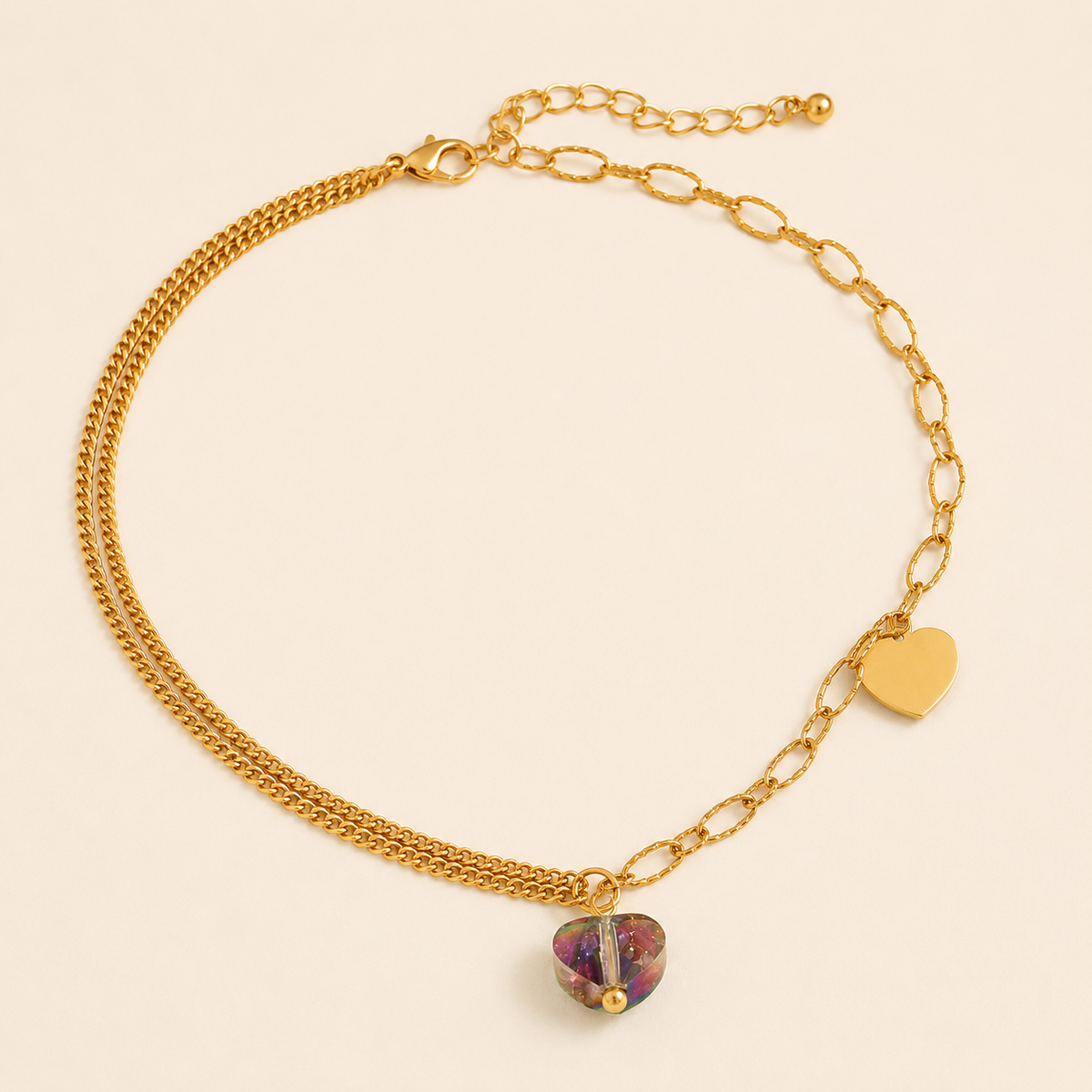 Mixed-chain gold anklet with solid gold and multicolour crystal heart charms on warm ivory