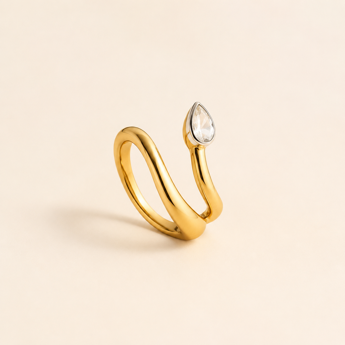 Two-Tone Wrap Ring with pear-cut crystal on luxury ivory background