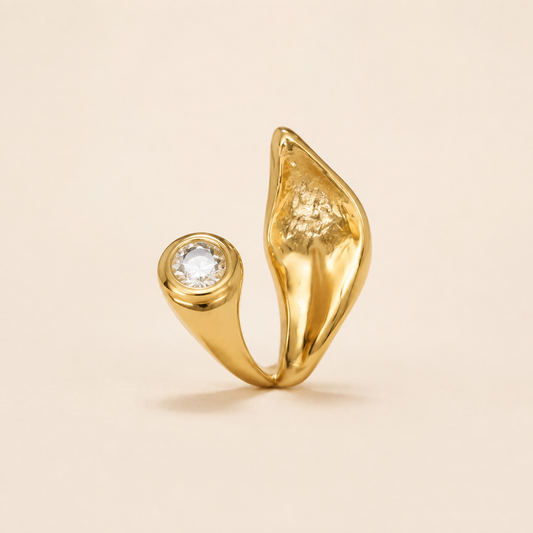Gold Zircon Solitaire Ring with sculptural leaf detail on luxury ivory background